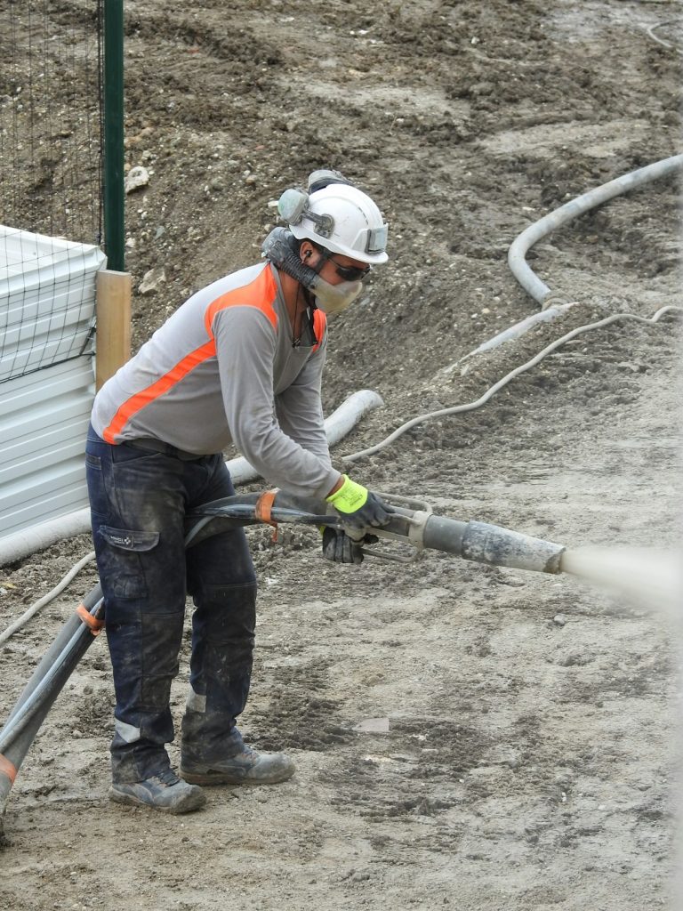 Hydroseeding technician applying seed and mulch mix on a residential construction site in South East Queensland